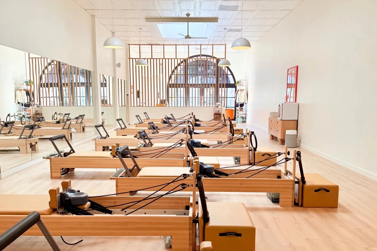 Reformer machines in a bright Mighty Pilates studio
